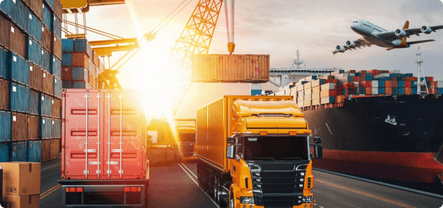 Semi-trucks being loaded at a dock with a ship and plane in the background